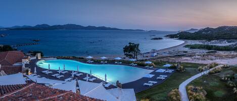 A resort with a swimming pool, beach access, and mountainous views.