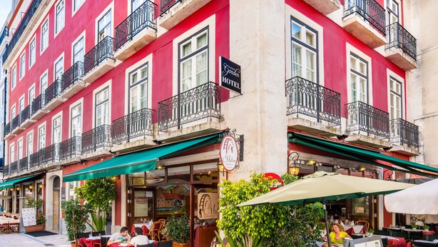 Un bâtiment rouge doté de balcons et d’une terrasse.