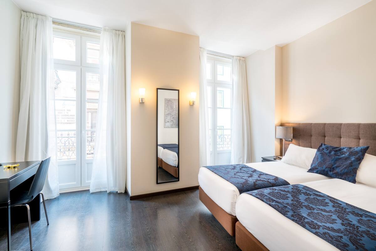 Een hotelkamer met een bed, een bureau en een stoel.