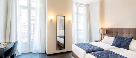Hotellihuone, jossa on sänky, työpöytä ja tuoli.