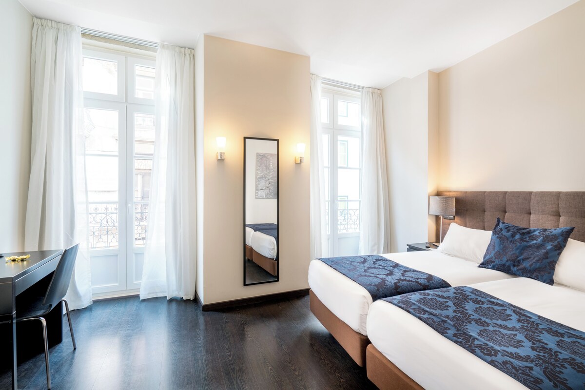 Une chambre d’hôtel avec un lit, un bureau et une chaise.