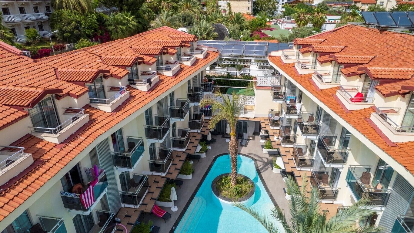 Un hôtel à plusieurs étages doté d’une piscine, de balcons et de panneaux solaires.