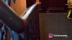 Een hotelingang met een houten deur en een metalen poort.