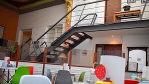Een eethoek met een trap naar een hoger niveau, moderne stoelen en uitzicht op het interieur.