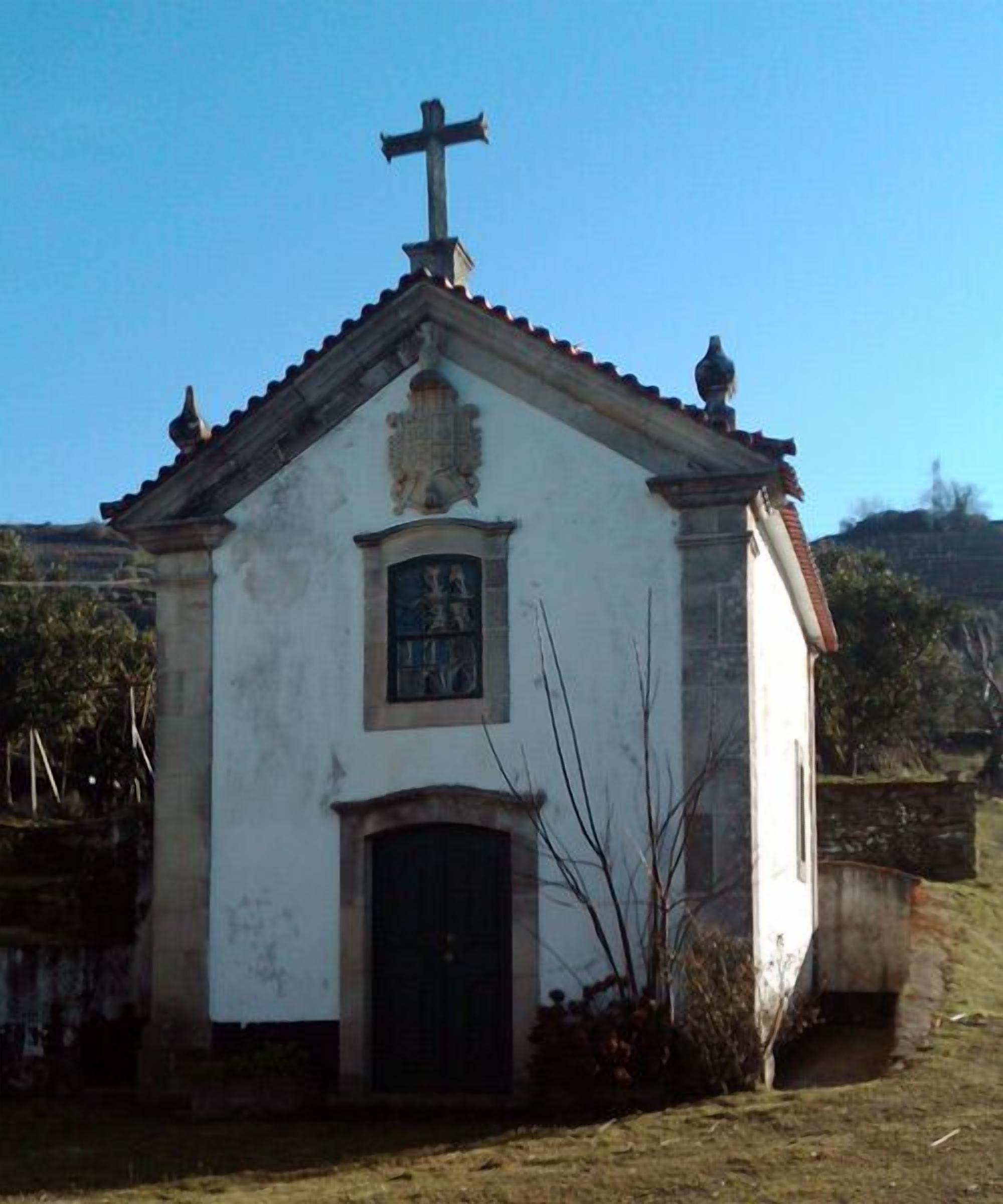 A small, single-story building with a cross on top, a small window, and a door.