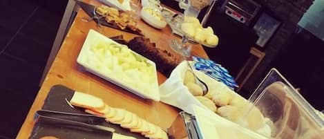 A buffet with various meats and cheeses.