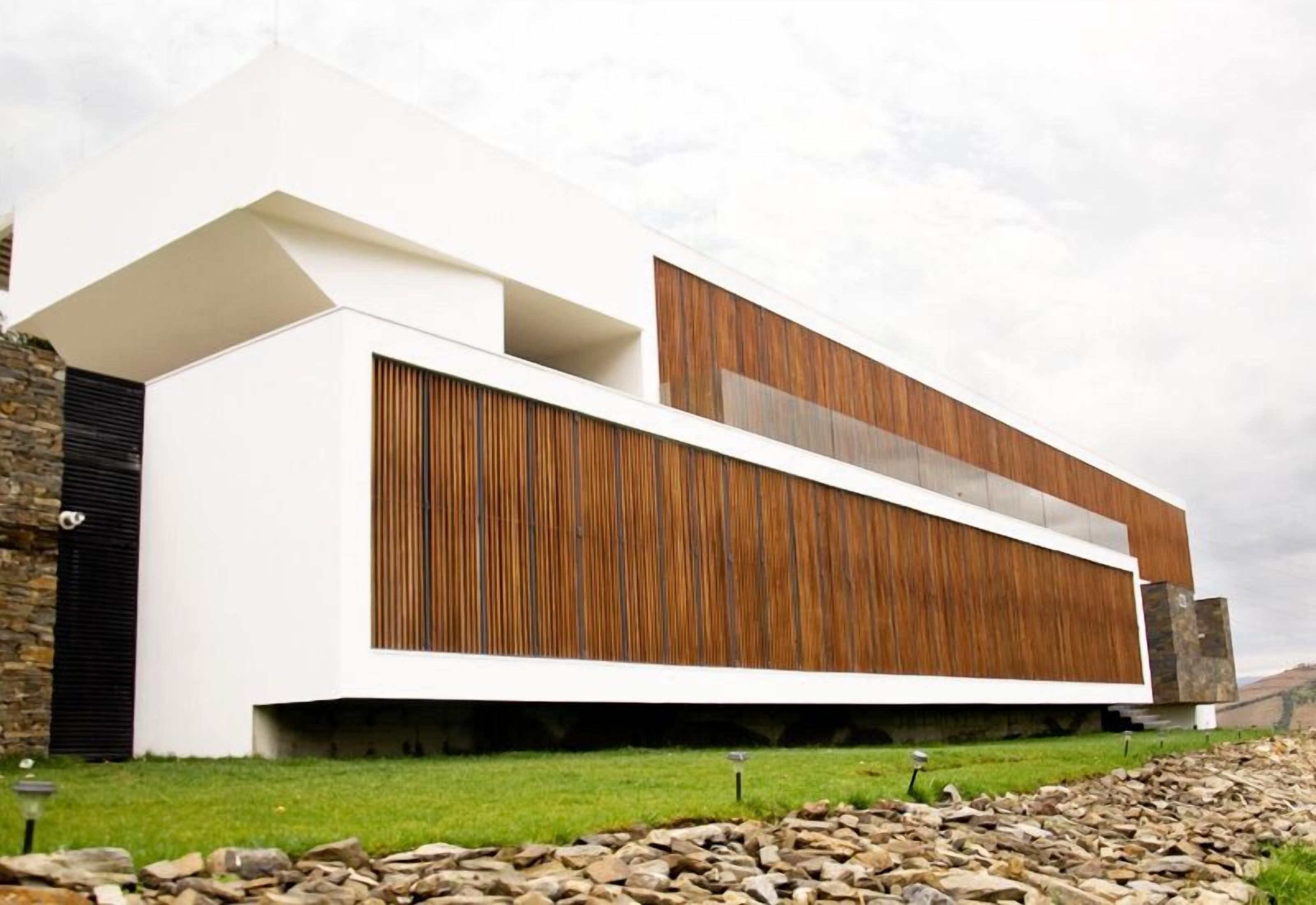 Un edificio moderno con techo plano, paredes blancas y paneles de madera.