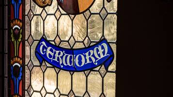 A stained glass window with heraldic designs and the inscription "Certa Ord".
