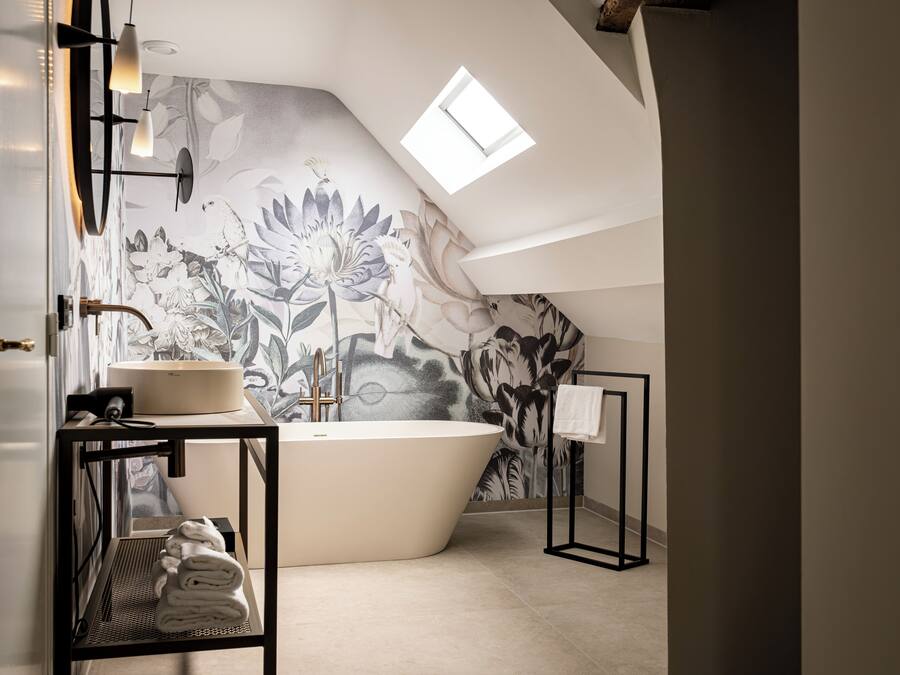 A modern bathroom with a freestanding bathtub, a sink, and a towel rack.