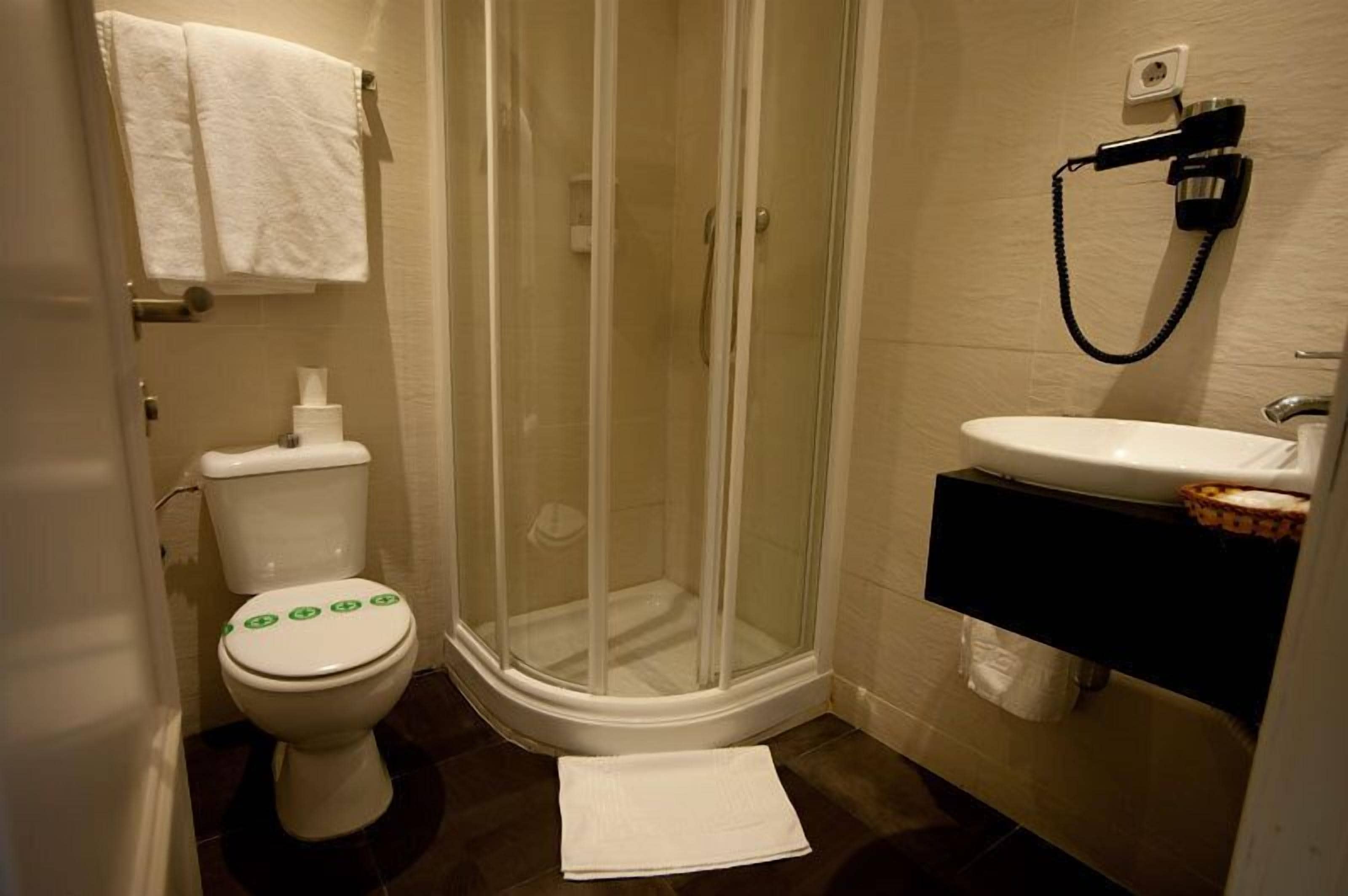 Un baño con inodoro, ducha y lavamanos.