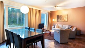 Una sala moderna con una mesa de vidrio, un sofá y un televisor.