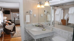 A modern bathroom with a large mirror, dual sinks, and a hairdryer.
