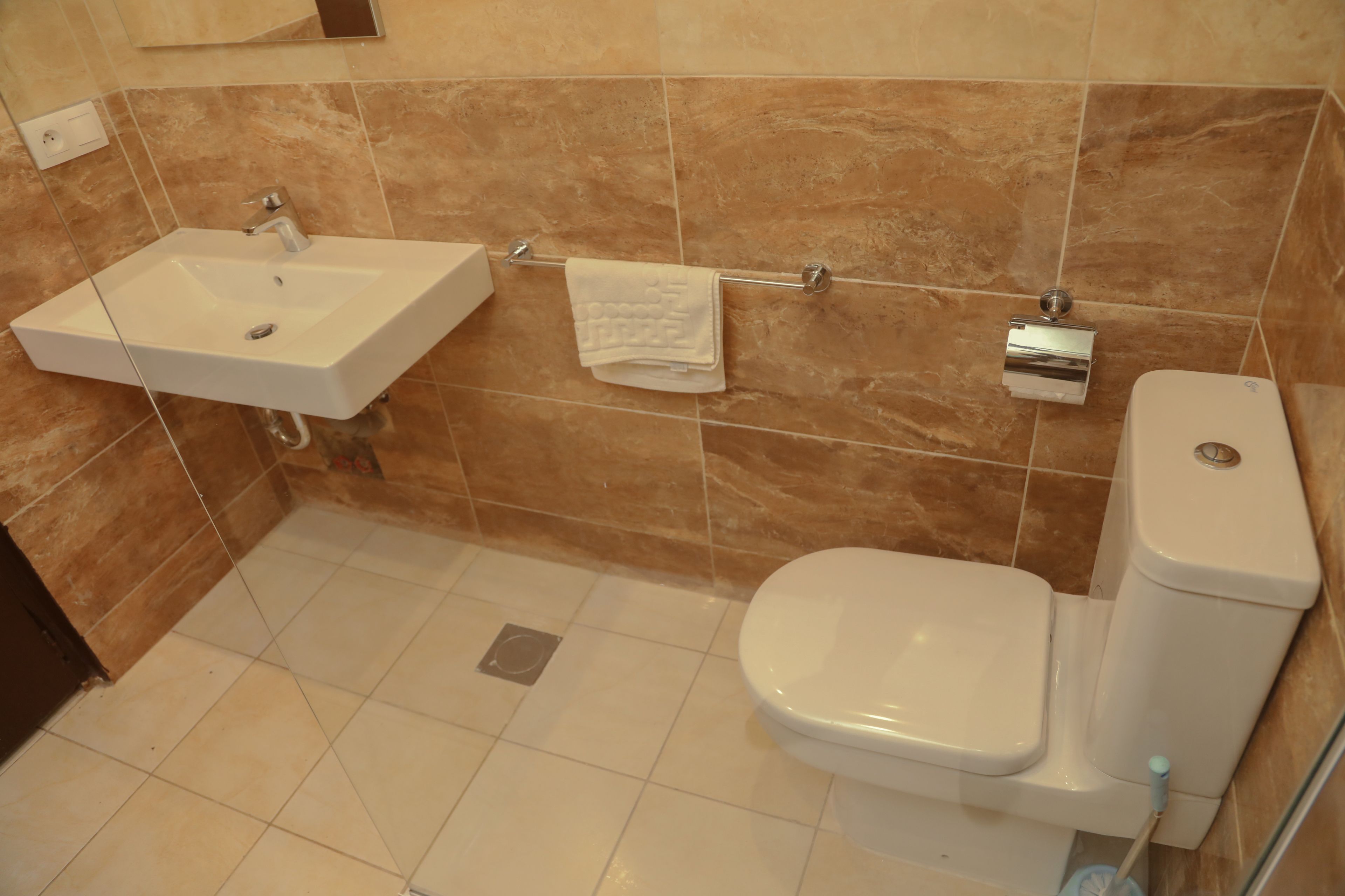 Ein Badezimmer mit Waschbecken, Toilette und Handtuchhalter.