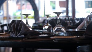 A restaurant setting with tables set for dining, featuring clear glassware and plates. - Riviera Taouyah Hotel (Conakry)