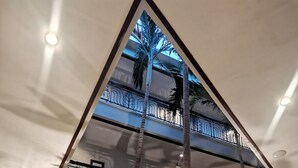 A multi-level atrium with a central water feature, palm trees, and a seating area. - Casa Leticia Business Inn (Davao)