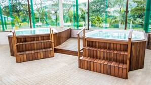 Een wellnessruimte met houten banken en een bubbelbad.