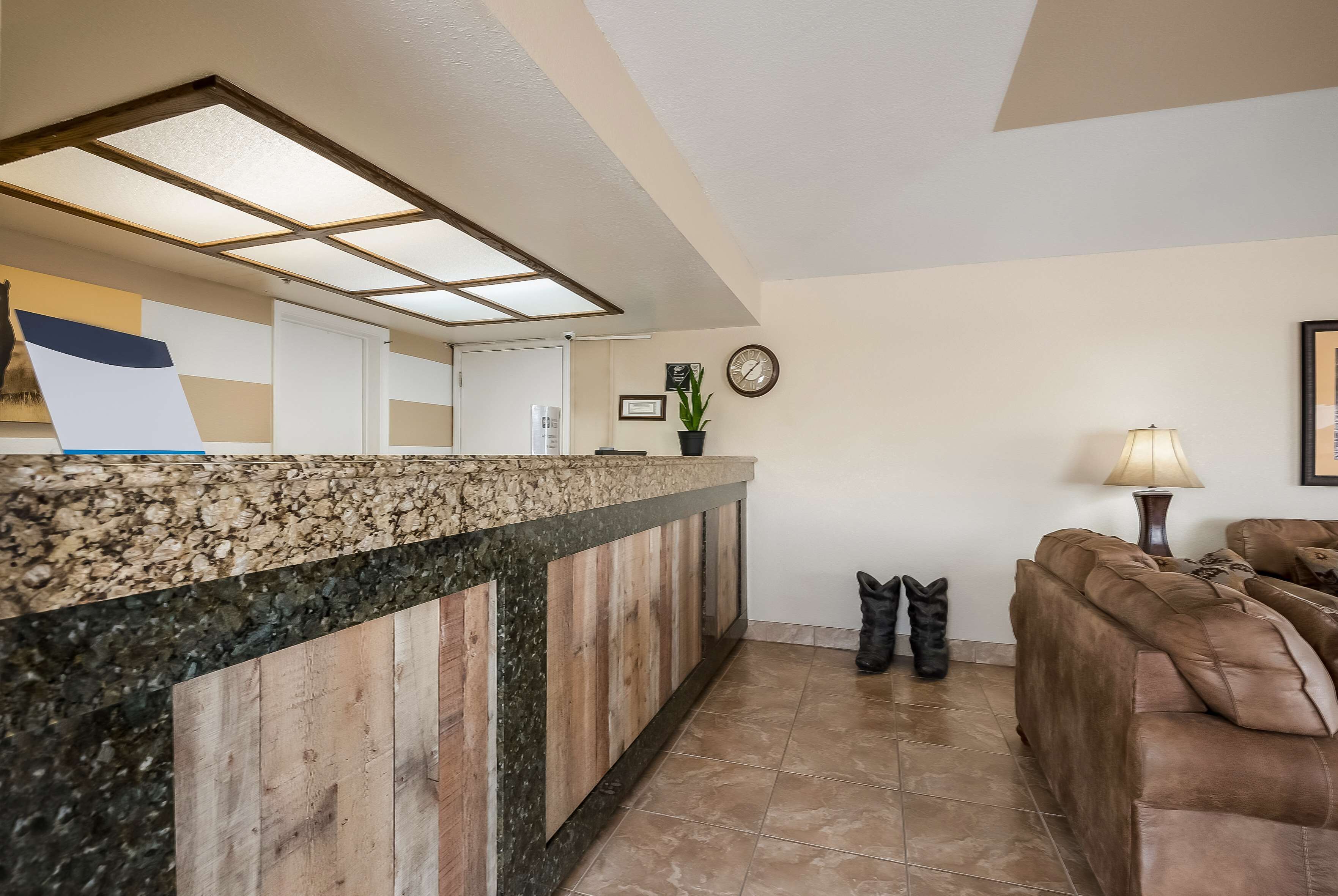 A reception area with a wooden counter, a clock, and a lamp.