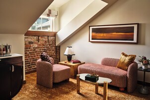 A cozy living room with a brick wall, a sofa, a coffee table, and a lamp.
