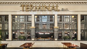 A building facade with a large illuminated sign reading "TERMINAL BAR" above a set of double doors. - The Crawford Hotel (Denver)