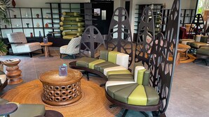 A modern lounge area with a curved sofa, a wooden coffee table, and a decorative partition.