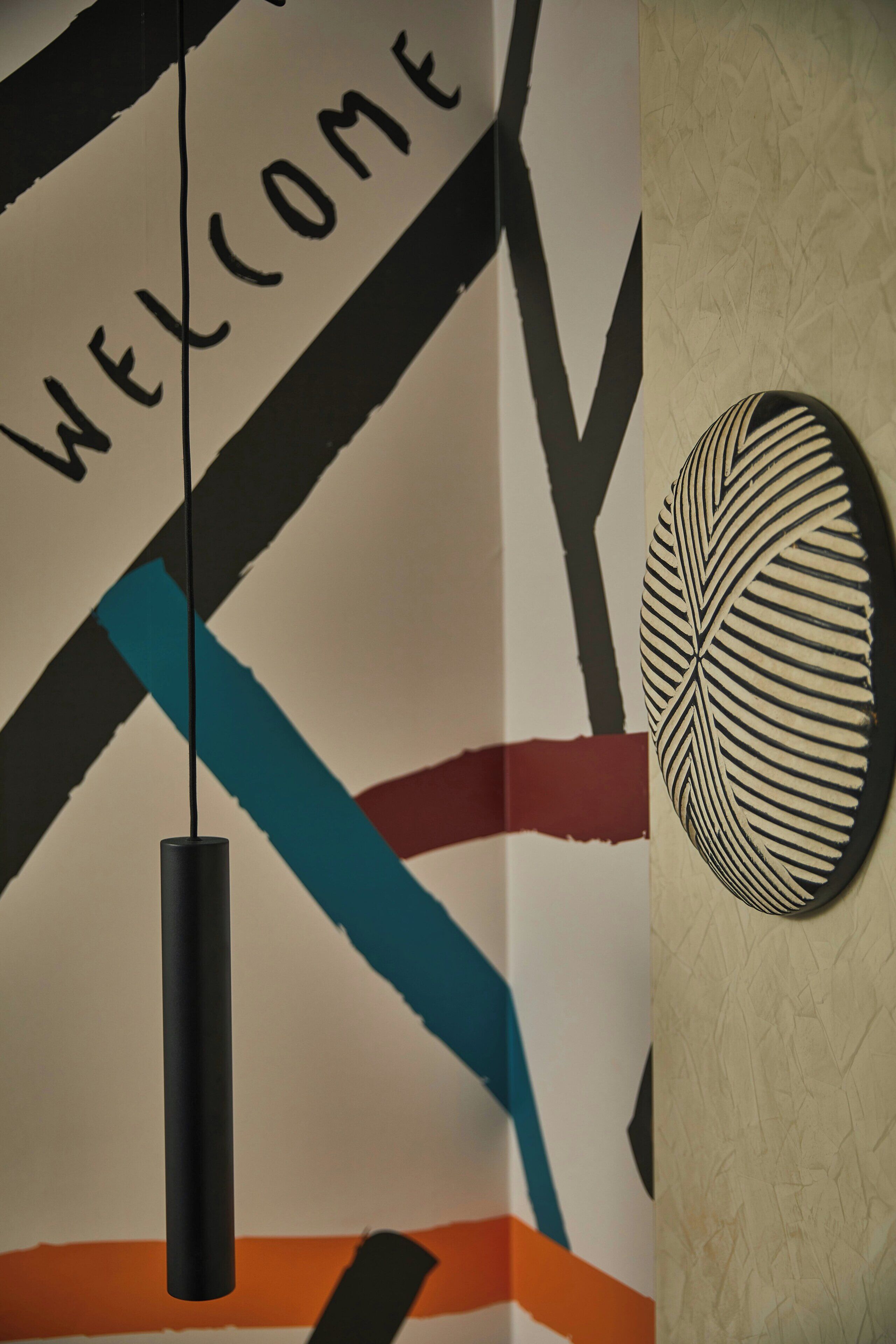 A wall with a 'WELCOME' sign and a decorative wall piece.