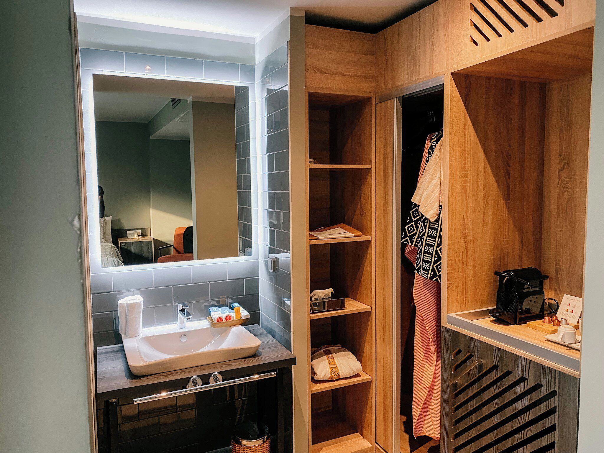 Un bany modern amb un lavabo, mirall i un moble de tocador de fusta.