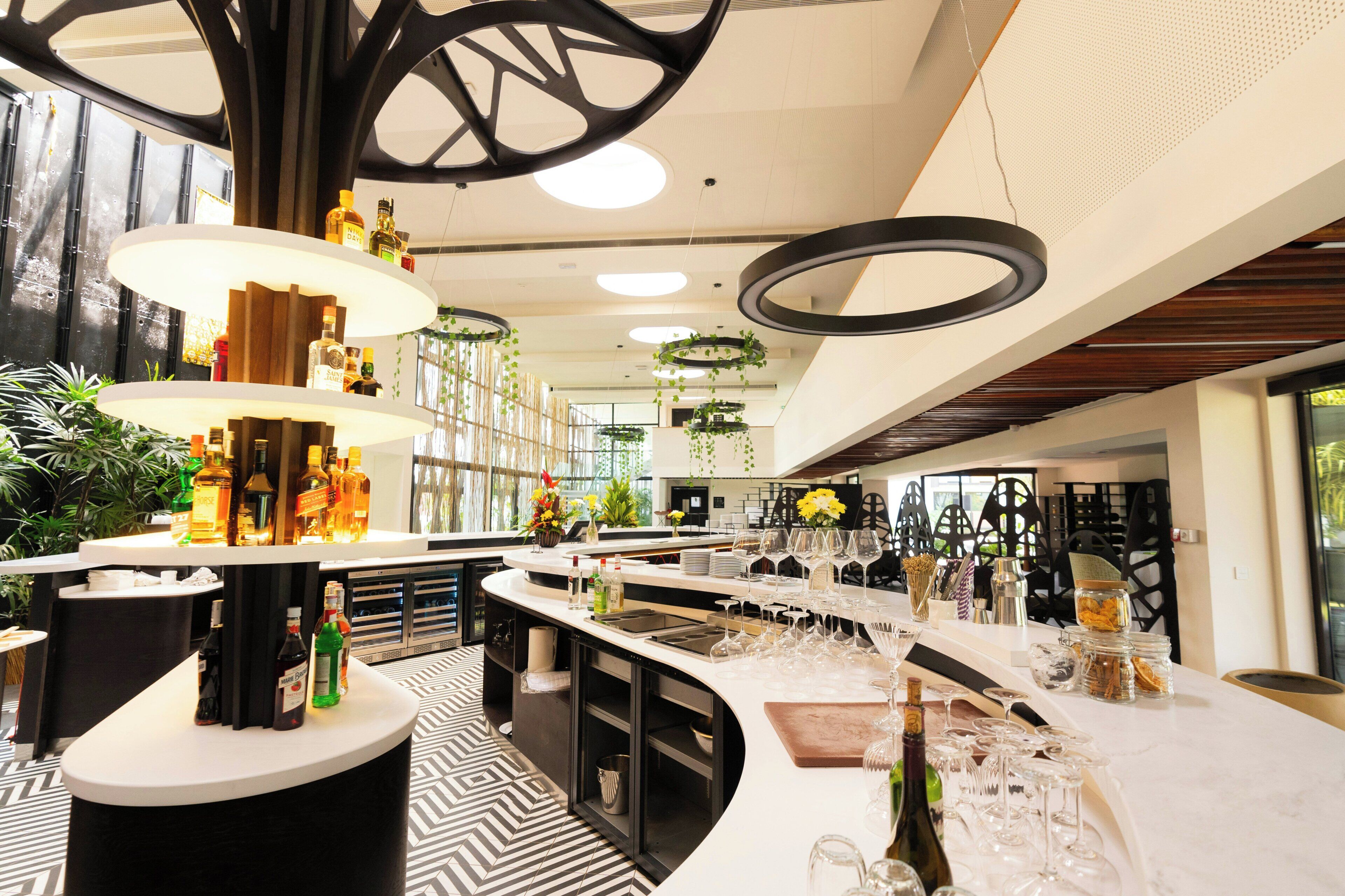 A modern bar area with multiple liquor dispensers, a variety of glassware, and a patterned floor.