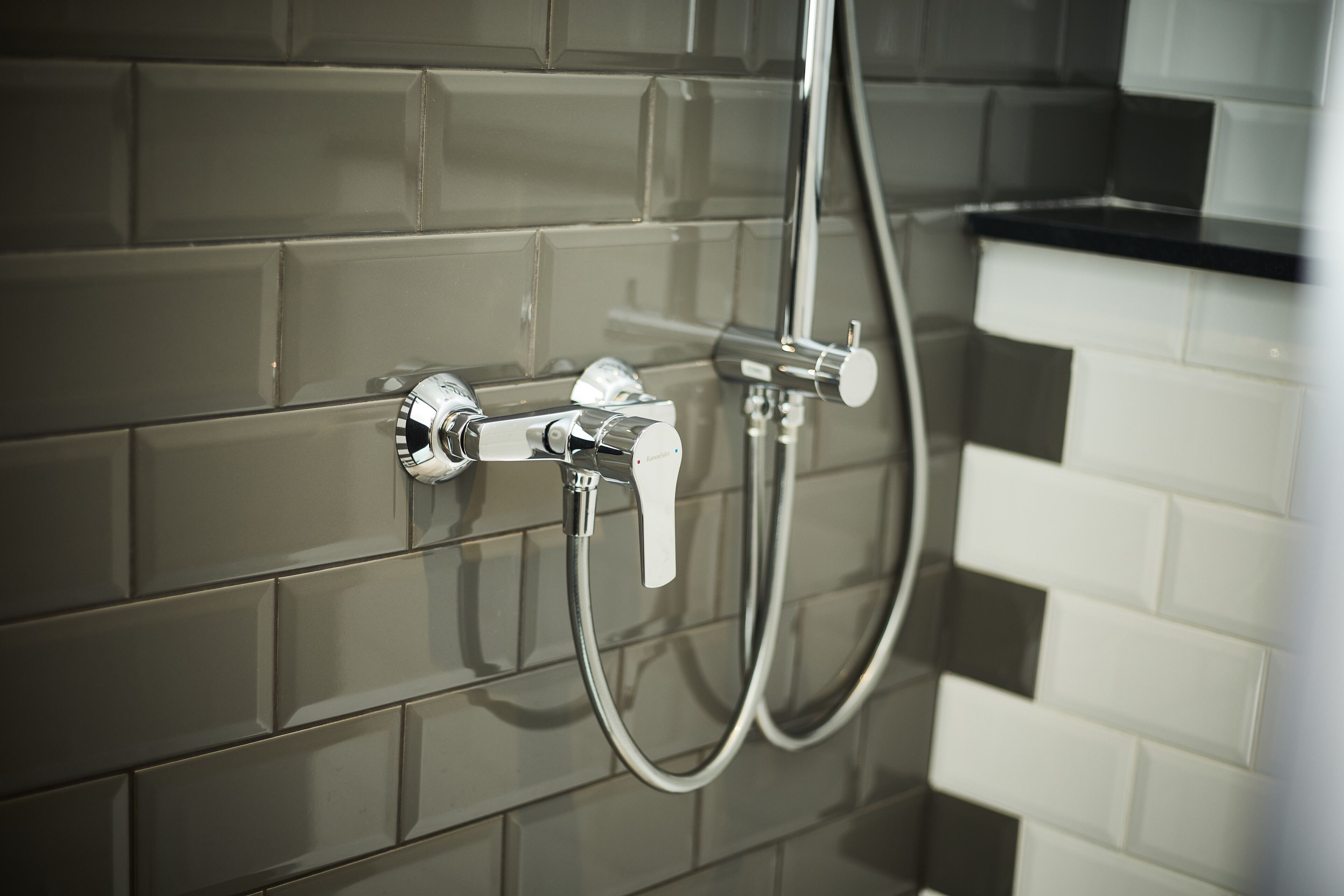 Baño con ducha moderna, que incluye un cabezal de ducha de mano y un grifo empotrado.