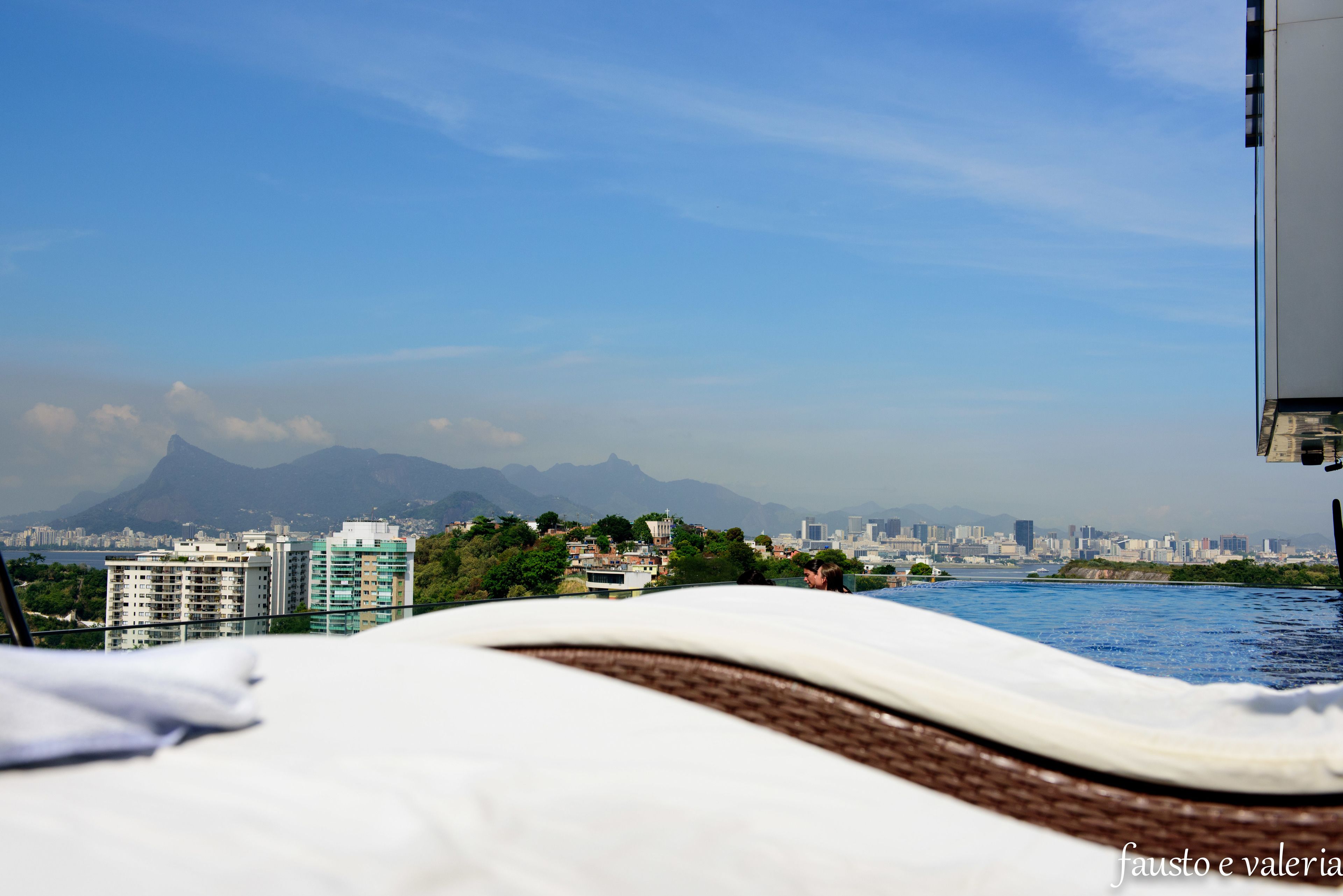 Ein Hotelzimmer mit Blick auf eine Stadtansicht und Berge in der Ferne.