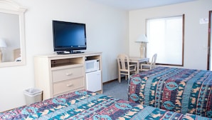 A hotel room with two beds, a desk, a television, a chair, and a window. - Starlite Motel (Wisconsin Dells)