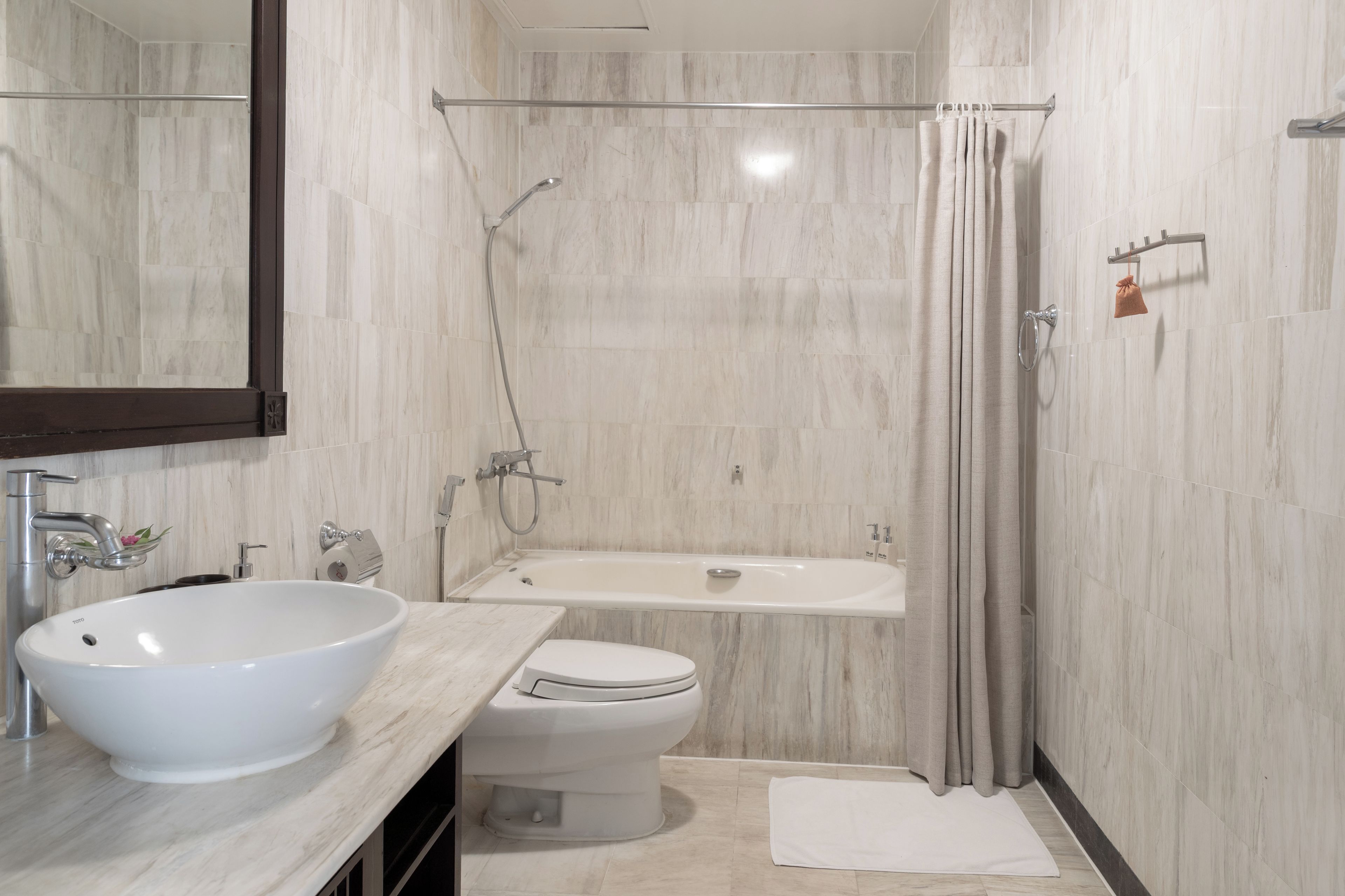 Une salle de bain moderne avec un grand lavabo blanc, des toilettes et une baignoire.