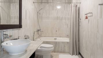 Une salle de bain moderne avec un grand lavabo blanc, des toilettes et une baignoire.