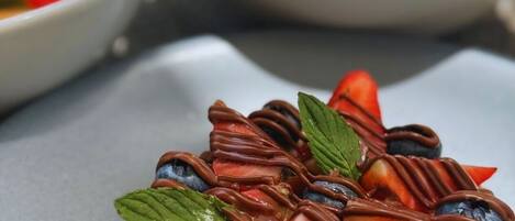 A dessert with chocolate and fruit on a plate.