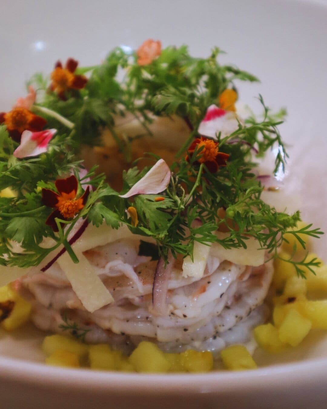 Un plat à base de fruits de mer, d’herbes aromatiques et de légumes coupés en dés.