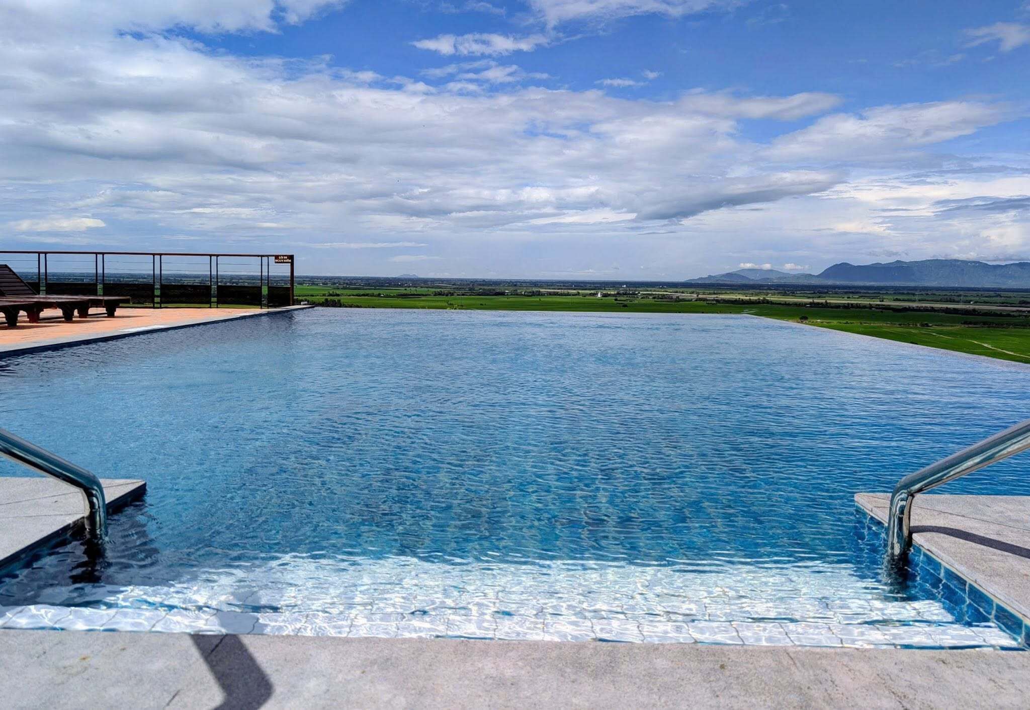 A swimming pool with a view of distant mountains and a clear sky.