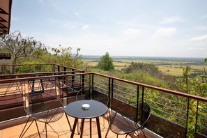 Una terraza con mesa y sillas, con vistas a un paisaje pintoresco.
