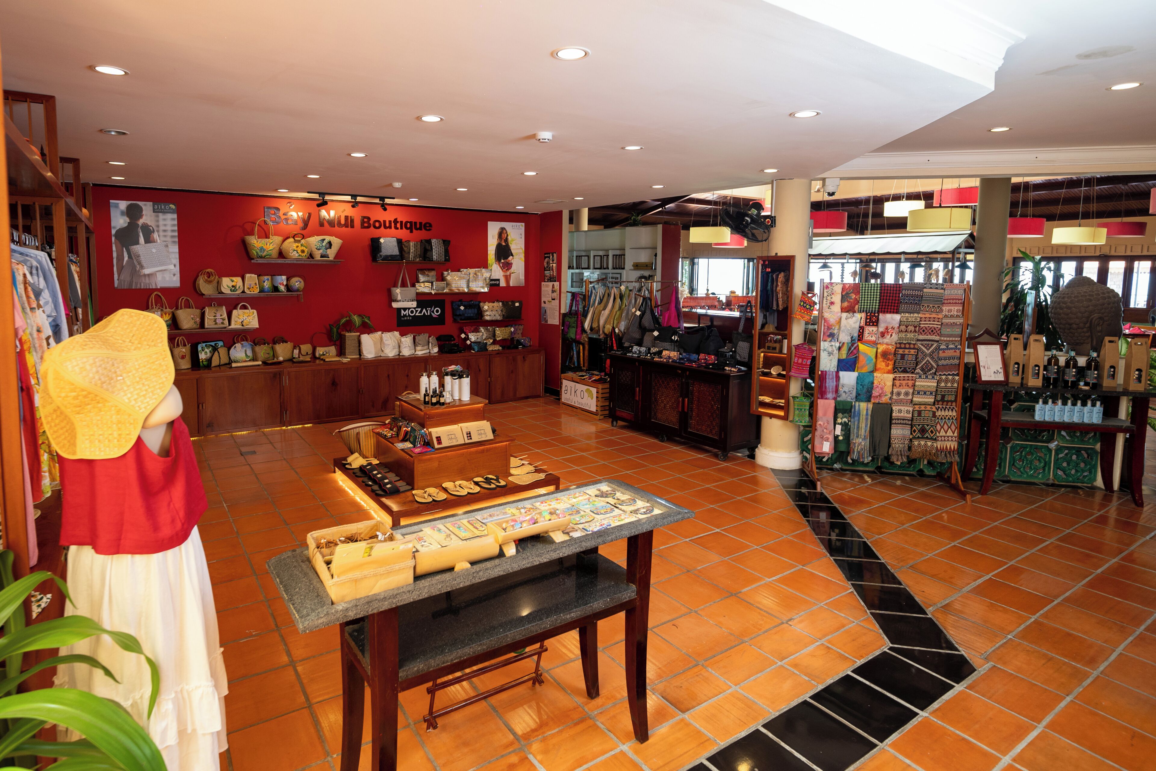 Une boutique proposant une variété de sacs et de chaussures, présentés sur des étagères et des tables.
