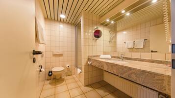 A modern bathroom with a toilet, sink, and shower.