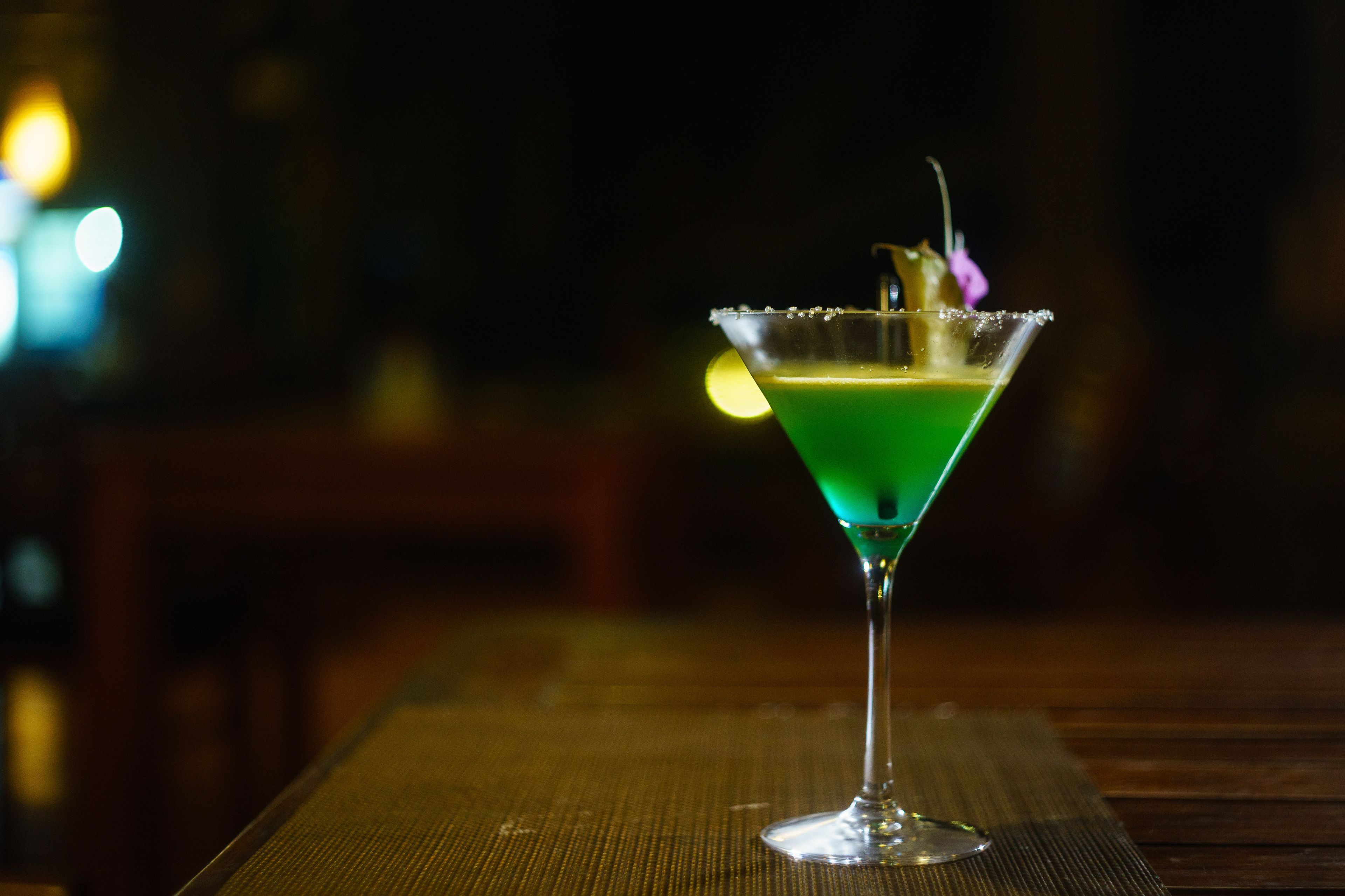 Ein Martini-Glas mit grüner Flüssigkeit auf einem Holztisch.