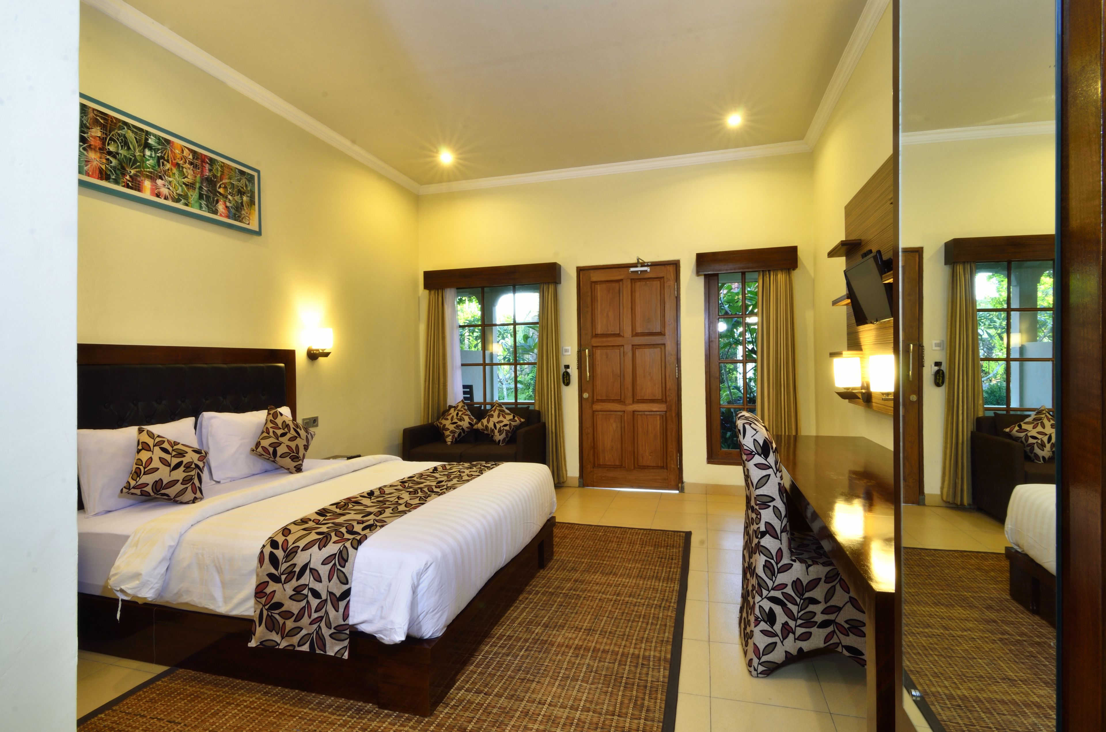 Une chambre d’hôtel avec un grand lit, un canapé, un bureau et une porte.