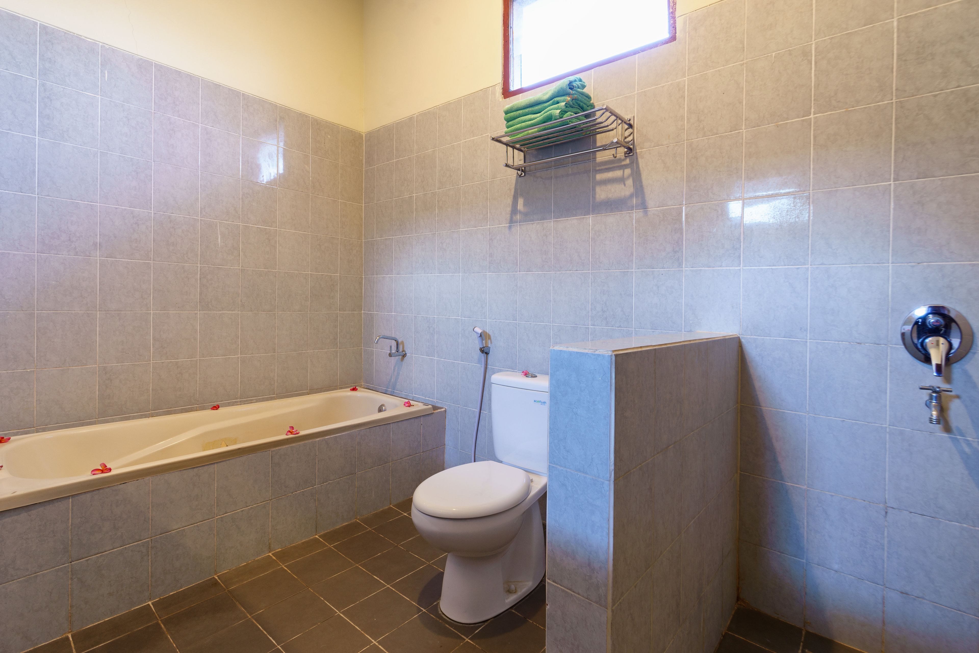 Un baño con bañera, inodoro y un perchero para toallas.