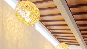 A hallway with wooden doors and a person holding a tray. - Delu Villas Suite Seminyak (Seminyak)
