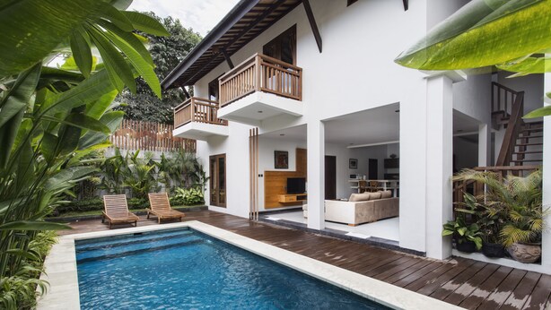 A modern house with a pool, wooden deck, and outdoor furniture. - Delu Villas Suite Seminyak (Seminyak)
