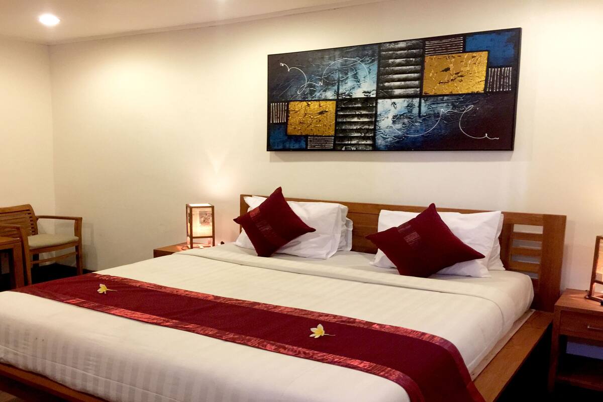 A hotel room with a bed, a desk, and a chair.
