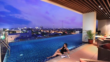Una piscina al aire libre, tumbonas