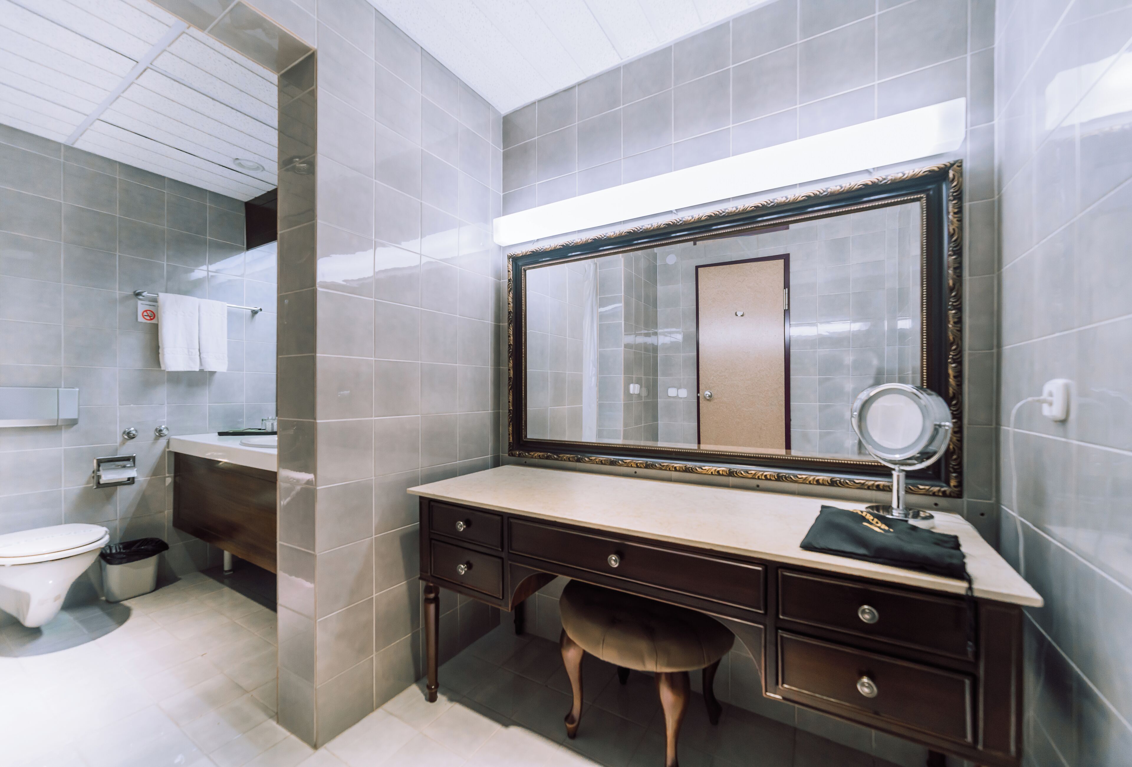 A bathroom with a vanity, a mirror, and a toilet.