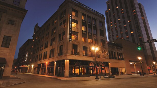 A multi-story hotel with a classic architectural design, featuring large windows and a prominent entrance with a canopy.