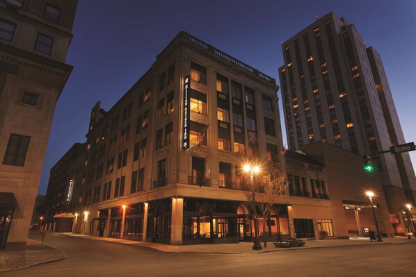 A multi-story hotel with a classic architectural design, featuring large windows and a prominent entrance with a canopy.