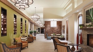 A spacious lobby with multiple seating areas, a fireplace, and modern lighting fixtures. - Hilton Garden Inn Rochester Downtown, NY (Rochester)