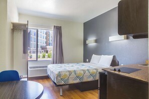 A hotel room with a bed, a desk, a chair, and a window with curtains. - Motel 6 Laredo, TX - Airport (Laredo)